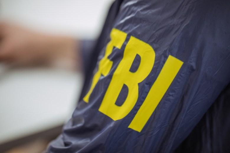 An FBI logo appears on a federal agent's windbreaker.