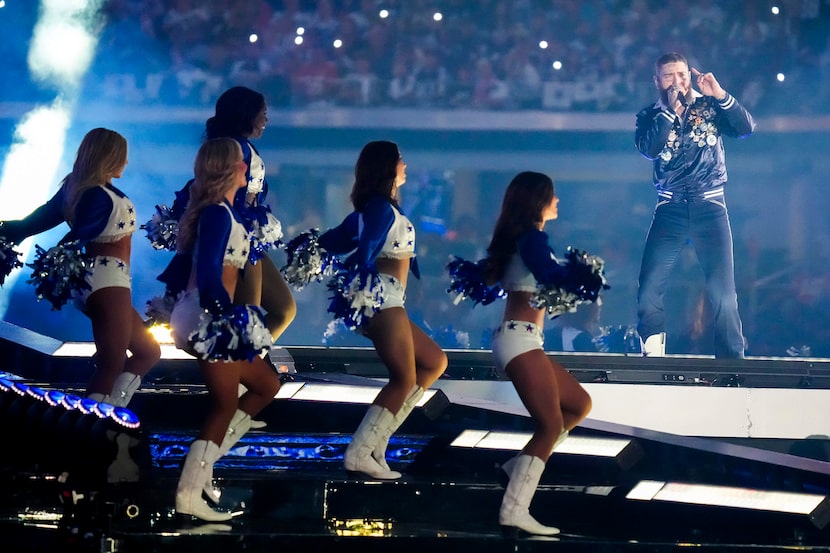 Post Malone performs with the Dallas Cowboys Cheerleaders during halftime of an NFL football...