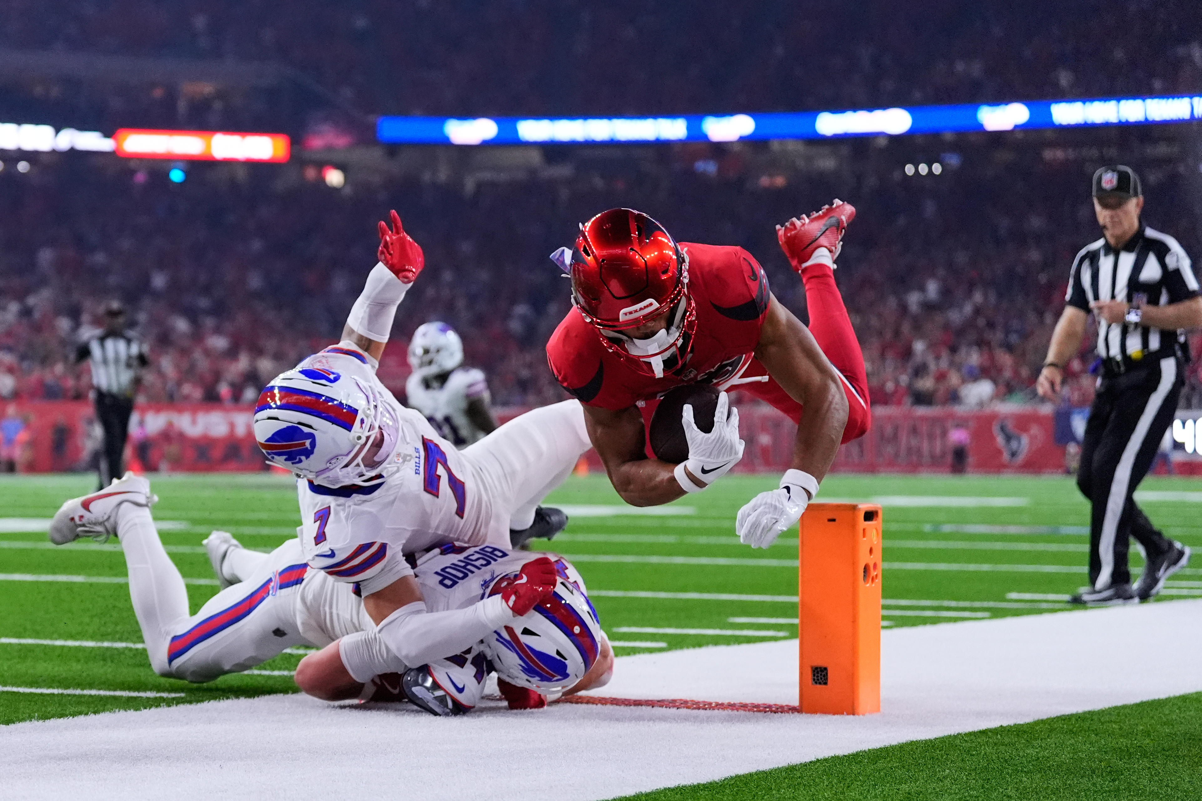Houston Texans wide receiver Xavier Hutchinson, right, is tackled by Buffalo Bills' Taron Johnson (7) and Cole Bishop (24) in the first half of an NFL football game Thursday, Nov. 20, 2025, in Houston. (AP Photo/Ashley Landis)