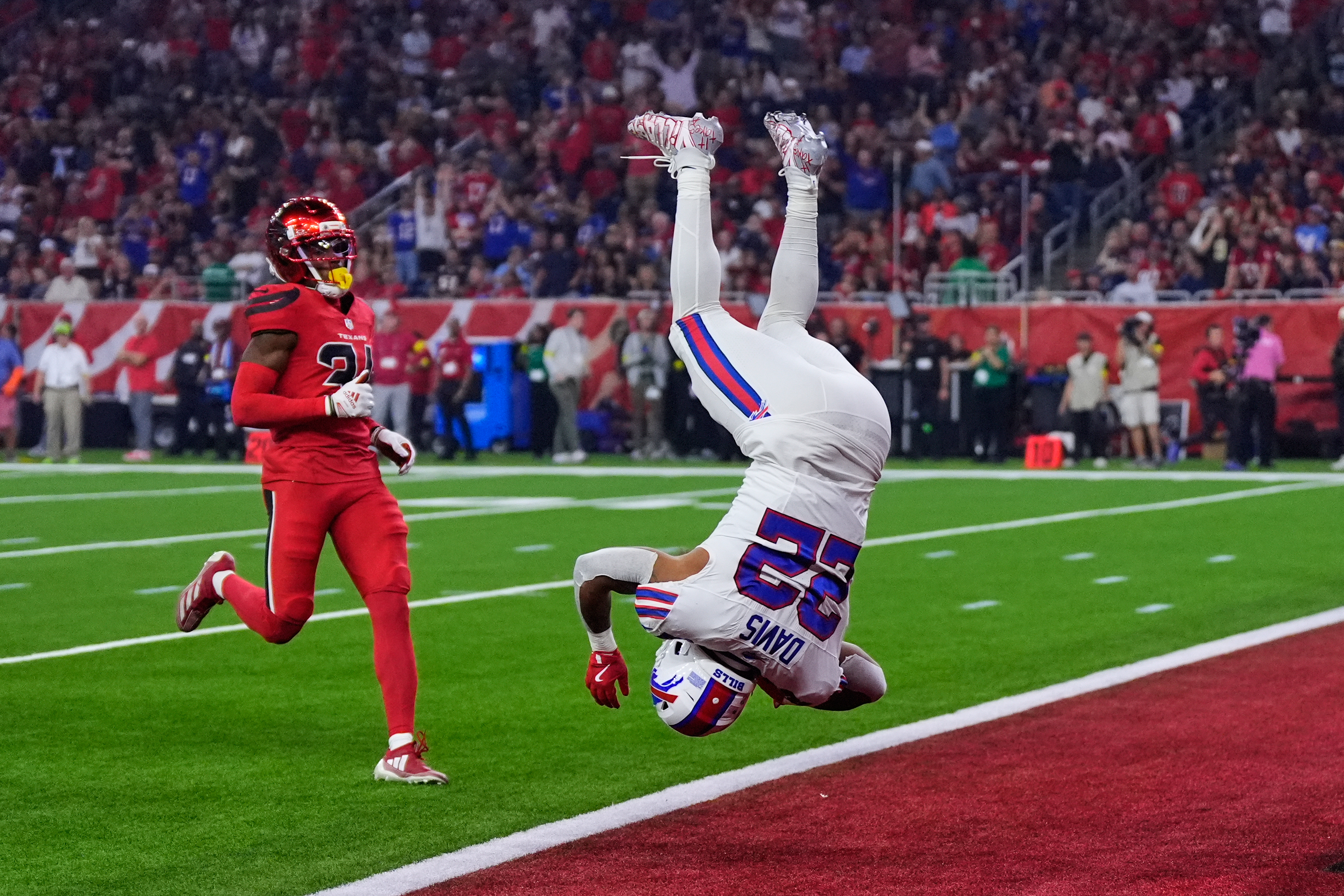 Buffalo Bills running back Ray Davis (22) leaps into the end zone after returning a kick-off for a touchdown as Houston Texans' Ajani Carter, left, looks on in the first half of an NFL football game Thursday, Nov. 20, 2025, in Houston. (AP Photo/Ashley Landis)