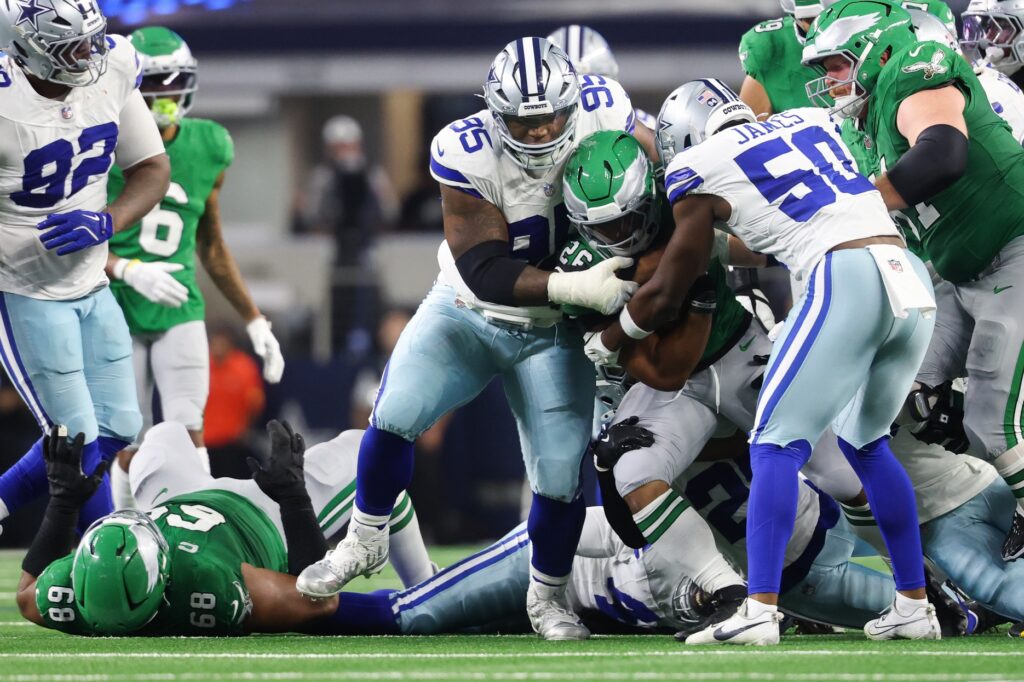 Nov 23, 2025; Arlington, Texas, USA; Philadelphia Eagles running back Saquon Barkley (26) is tackled by Dallas Cowboys defensive tackle Kenny Clark (95) in the third quarter at AT&T Stadium.