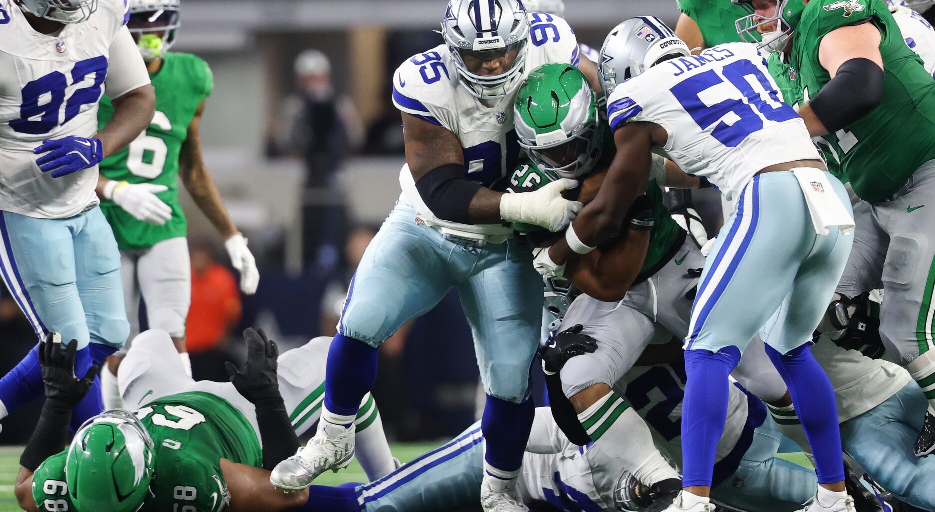 Nov 23, 2025; Arlington, Texas, USA; Philadelphia Eagles running back Saquon Barkley (26) is tackled by Dallas Cowboys defensive tackle Kenny Clark (95) in the third quarter at AT&T Stadium.