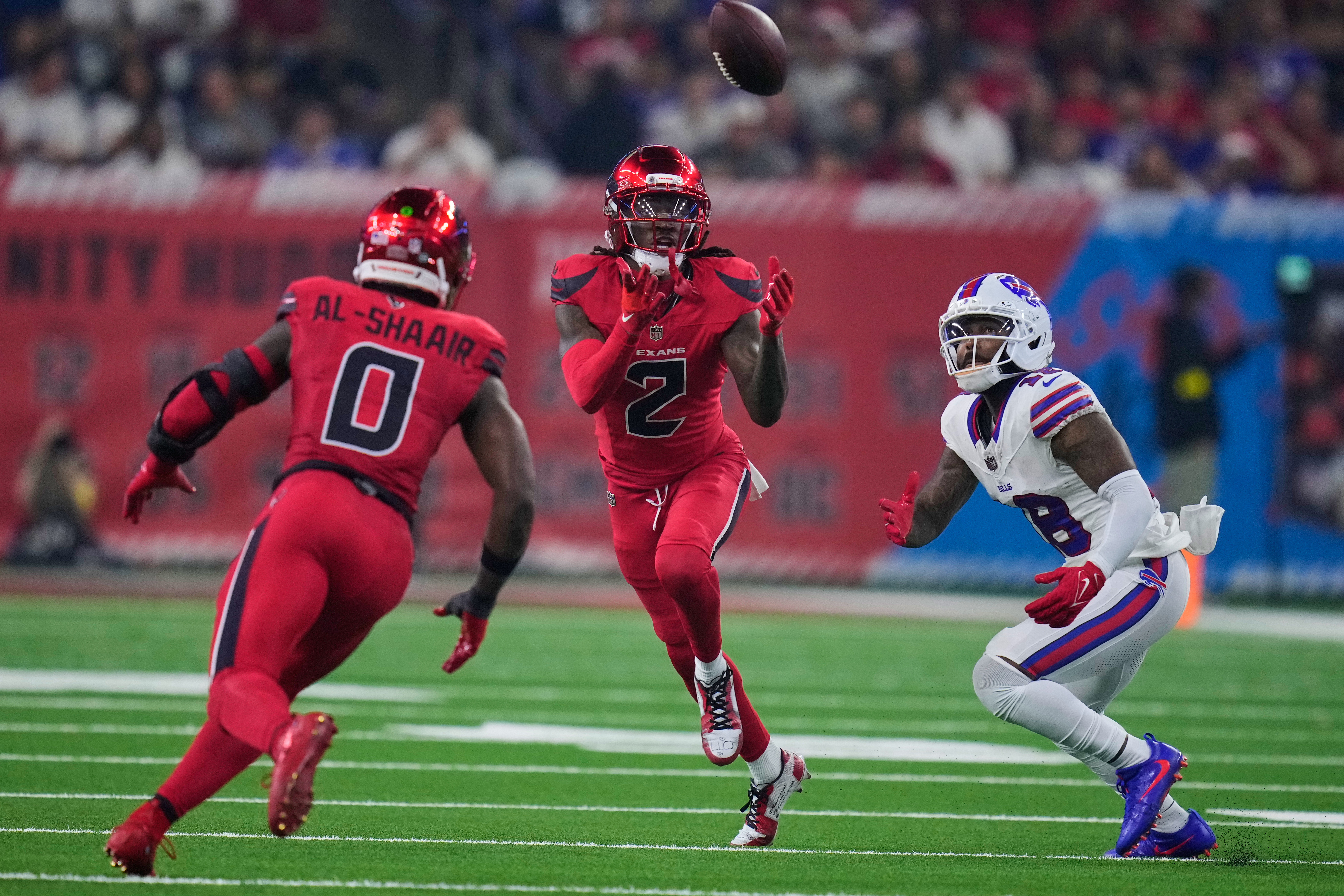 Houston Texans safety Calen Bullock (2) intercepts a pass as Azeez Al-Shaair (0) and Buffalo Bills wide receiver Elijah Moore (18) look on in the first half of an NFL football game Thursday, Nov. 20, 2025, in Houston. (AP Photo/Eric Christian Smith)