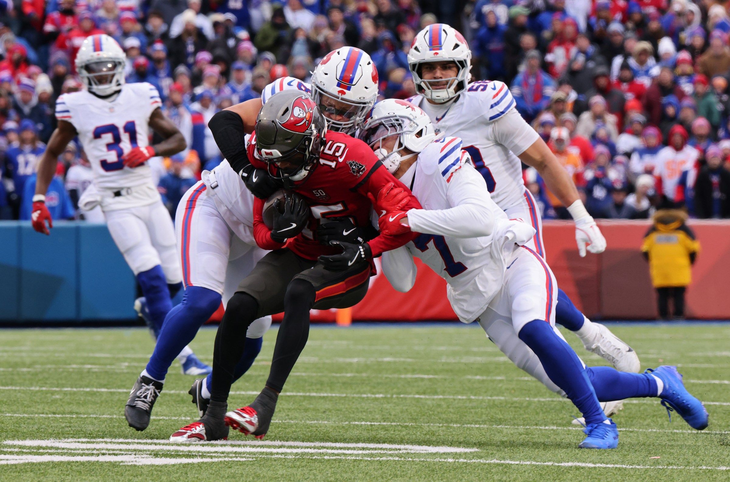 ORCHARD PARK, NEW YORK - NOVEMBER 16: Tez Johnson #15 of the Tampa Bay Buccaneers is tackled by Terrel Bernard #8 and Taron Johnson #7 of the Buffalo Bills during the second quarter at Highmark Stadium on November 16, 2025 in Orchard Park, New York. (Photo by Bryan M. Bennett/Getty Images)