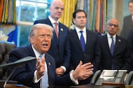 President Donald Trump answers questions from reporters during a meeting with the White...