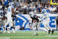 Detroit Lions linebacker Derrick Barnes, left, intercepts a pass intended for Dallas Cowboys...