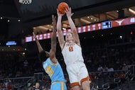 Texas center Matas Vokietaitis (8) shoots over Southern forward Terrance Dixon Jr. (23)...