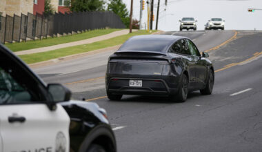 FILE — An Austin police car follows a driverless Tesla robotaxi in early July in Austin. Federal data show the company’s vehicles were involved in four crashes in the city during September.