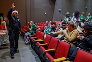 DISD police officer Omar Sepulveda (left) welcomes special education students to Operation...
