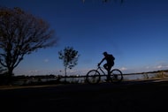 A man rides a bicycle along White Rock Lake, Saturday, Nov. 1, 2025, in Dallas. 