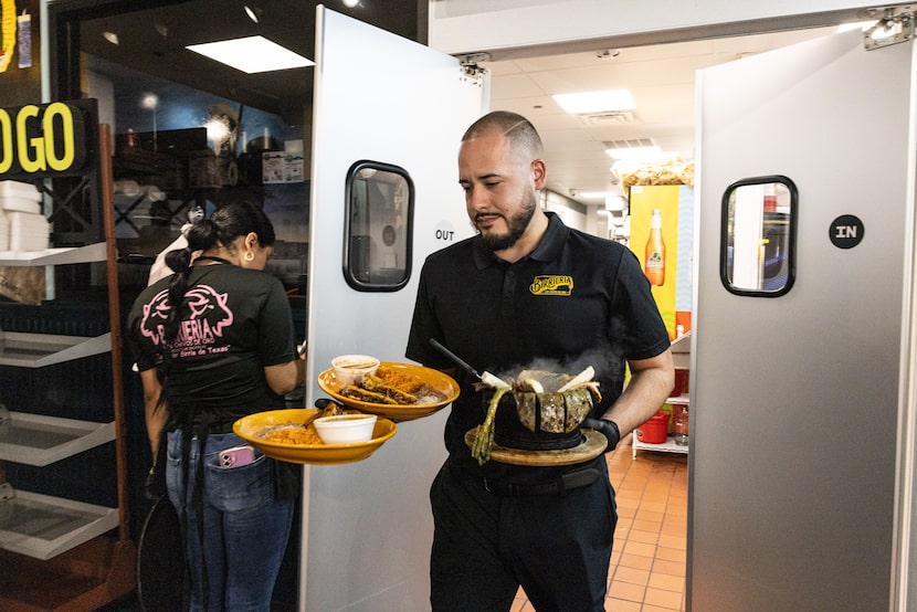 Ricardo Luis brings food out of the kitchen and serves diners during lunchtime at Birrieria...