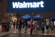 Customers form a line well before sunrise for the official grand opening of the new Walmart...
