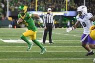 Oregon quarterback Dante Moore (5) runs away from James Madison defensive lineman Amar...