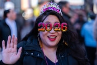 Teresa Hui, wears 2026 themed glasses as the 7-foot tall 2026 numerals are displayed at an...