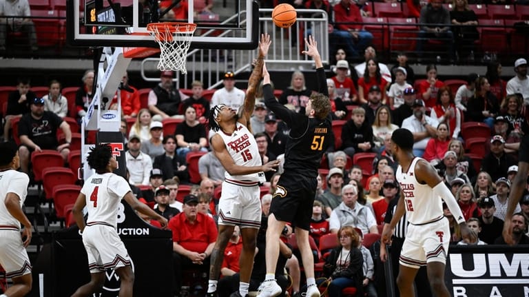 Winthrop center Logan Duncomb (51) attempts to shoot over Texas...