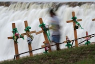 A girl runs past crosses at a makeshift memorial for Guadalupe River flood victims in...