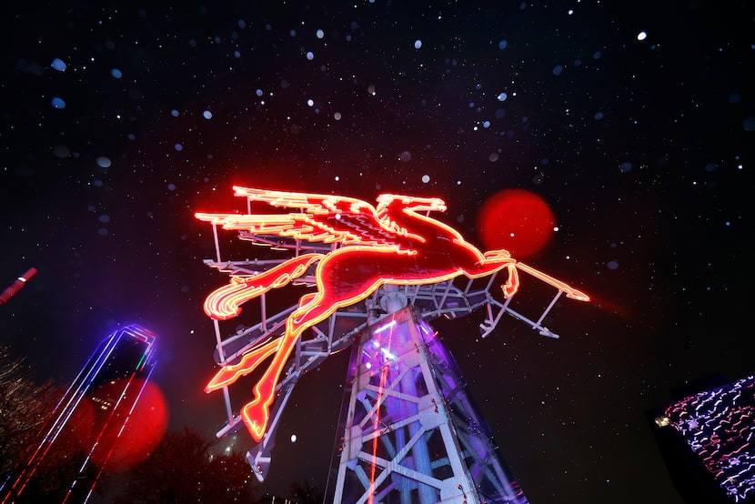 Rain turning to sleet falls late Thursday night, January 9, 2025 in front of neon red...