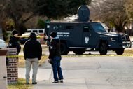 Grand Prairie police investigators work outside a home in the 1600 block of Avenue B in...