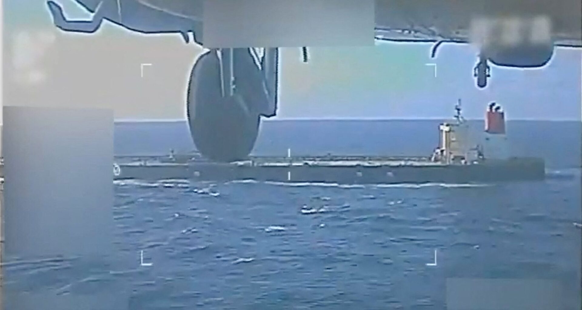 A U.S. military helicopter flies near an oil tanker during a raid described by U.S. Attorney General Pam Bondi as its seizure by the United States off the coast of Venezuela, December 10, 2025, in a still image from video