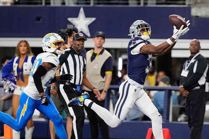 Dallas Cowboys wide receiver George Pickens (3) makes a touchdown catch past Los Angeles Chargers cornerback Cam Hart (20) during the first half of an NFL football game Sunday, Dec. 21, 2025, in Arlington, Texas. (AP Photo/Tony Gutierrez)