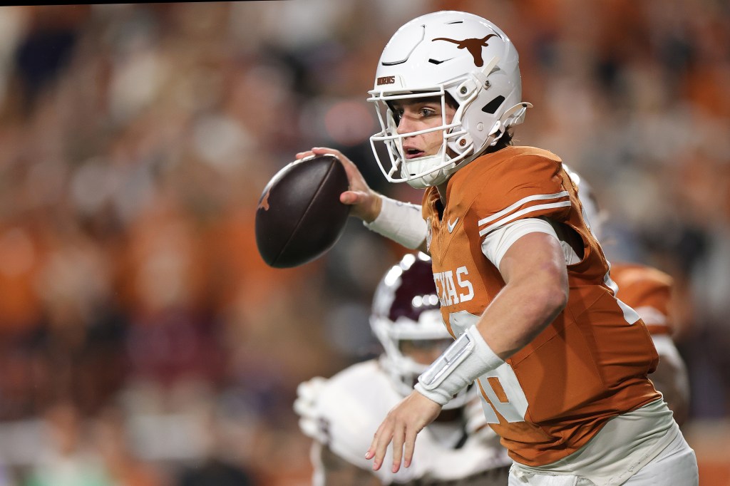 Arch Manning #16 of the Texas Longhorns scrambles out of the pocket during the first quarter as he looks to pass against the Texas A&M Aggies at Darrell K Royal-Texas Memorial Stadium on November 28, 2025 in Austin, Texas.