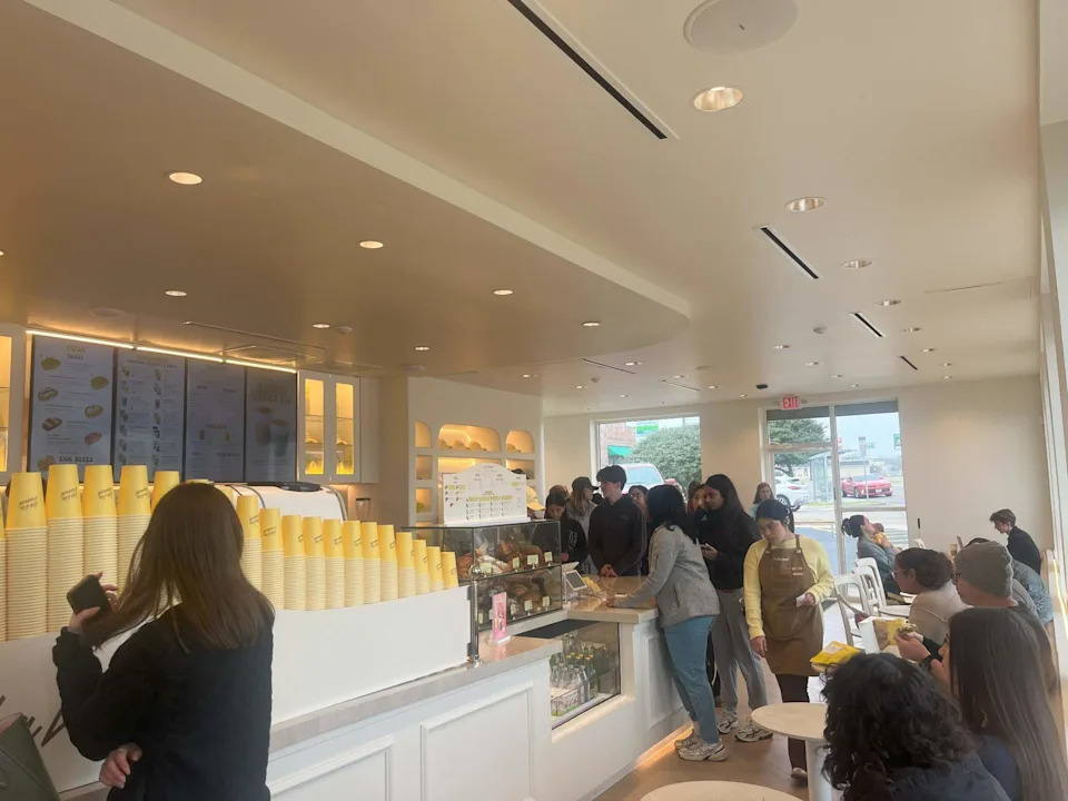 La La Land cafe in Fort Worth is bright white with yellow coffee cups to match their brand mission to make people happy.