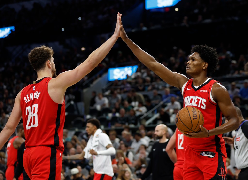 Alperen Sengun and Amen Thompson high-fiving during an NBA game.