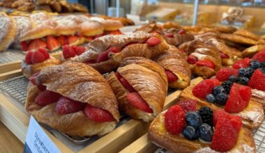 Fruit filled croissants in a bakery case.