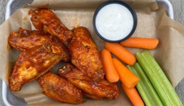 A plate of chicken wings, ranch, carrots and celery