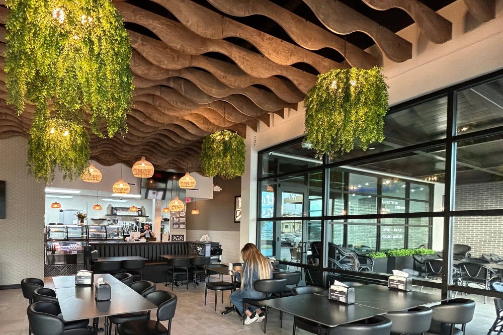 Interior of a restaurant featuring wood and botanical design elements.