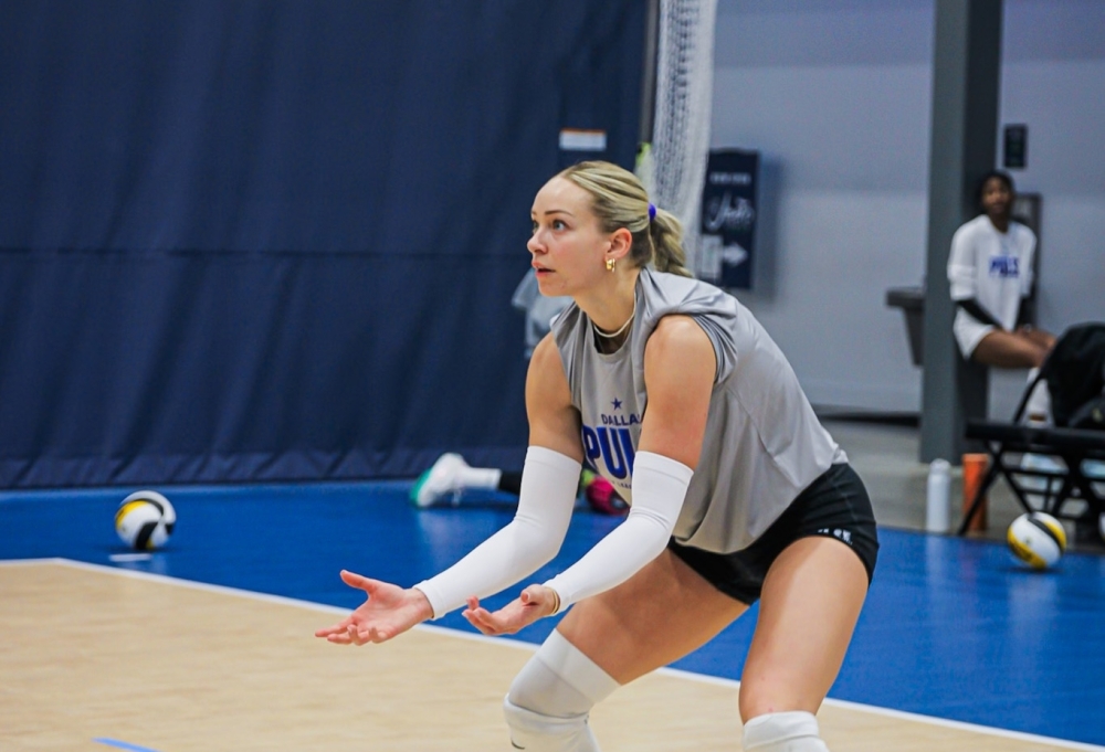 Dallas Pulse volleyball player Isabel Martin crouches with her hands in front of her