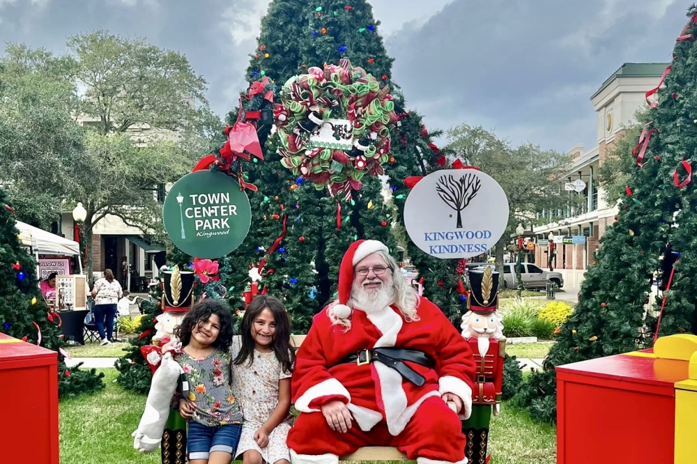 Santa with kids in front of a Christmas tree