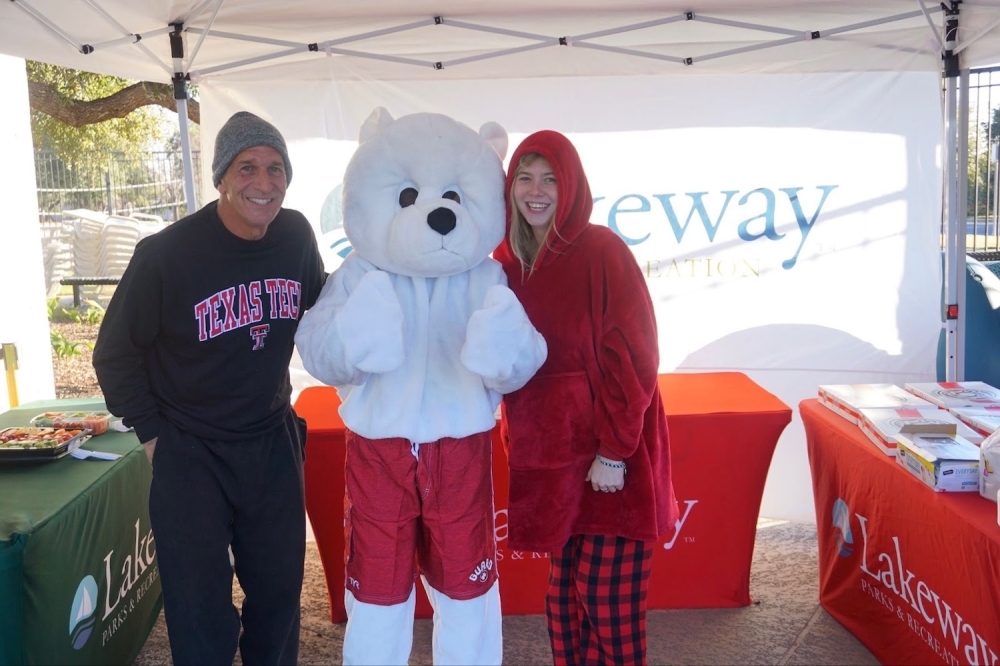 man and girl standing with person in polar bear costume