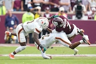 Texas A&M wide receiver KC Concepcion (7) is tackled by Miami defensive back Zechariah...