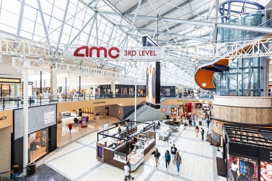 Interior of a two-story mall featuring glass and beam celings.