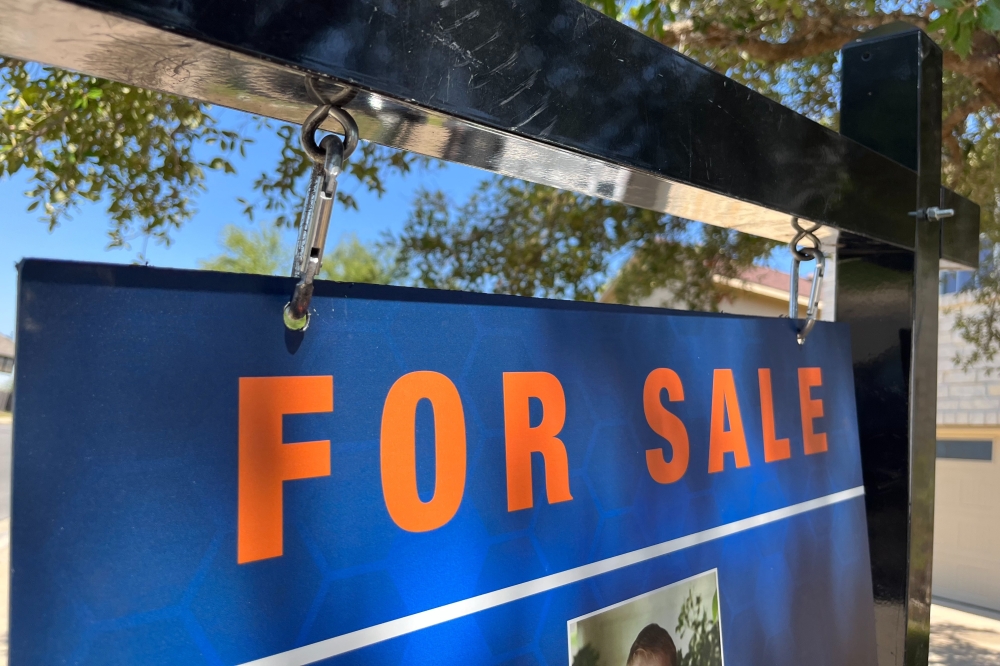 For sale sign in front of house