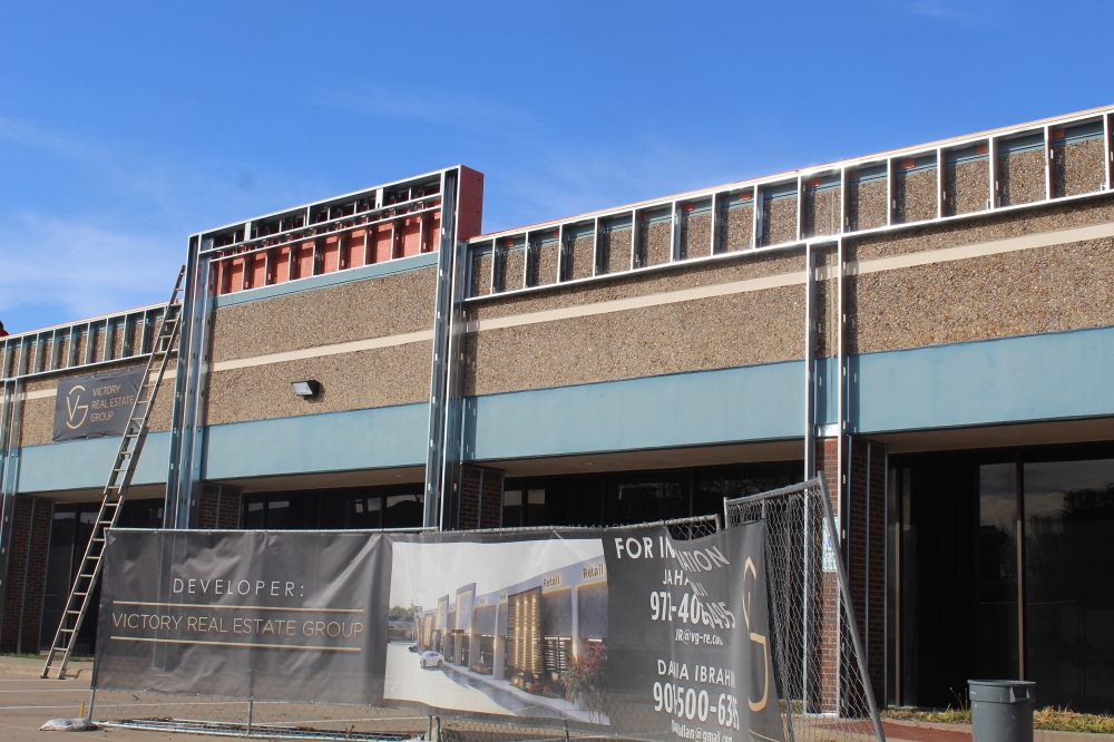 A Victory Real Estate Group banner in front of a building with construction scaffolding
