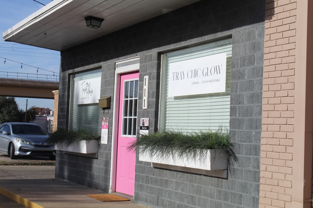 A storefront with a bright pink door