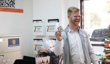 A man in a printing shop smiling and holding a business card