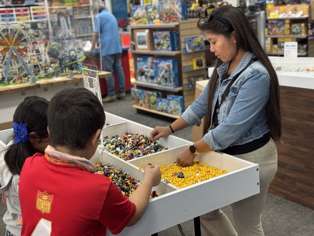 Karly Newberry and her two kids sort through loose pieces at Bricks & Minifigs in far Northwest Austin. (Community Impact staff)