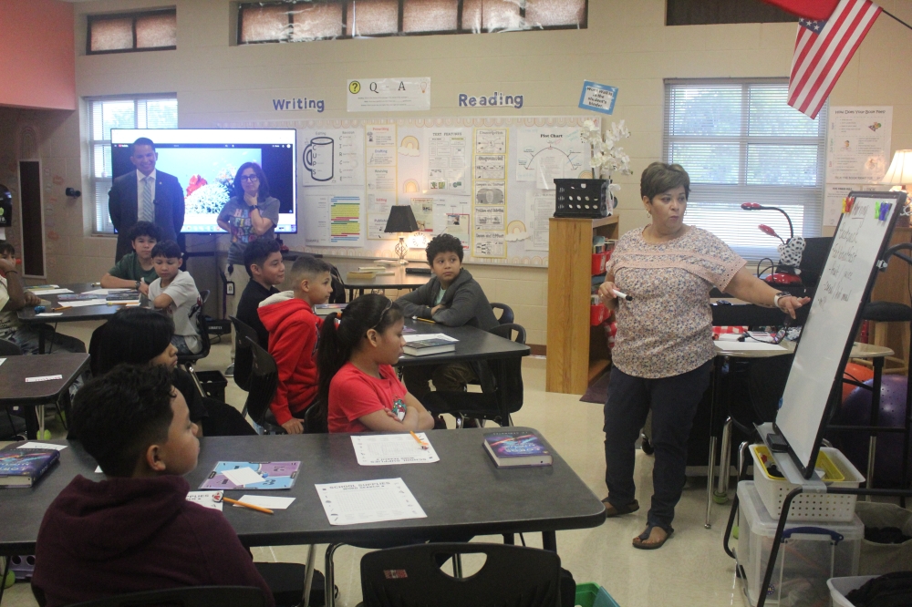 A teacher presents to a class of elementary students