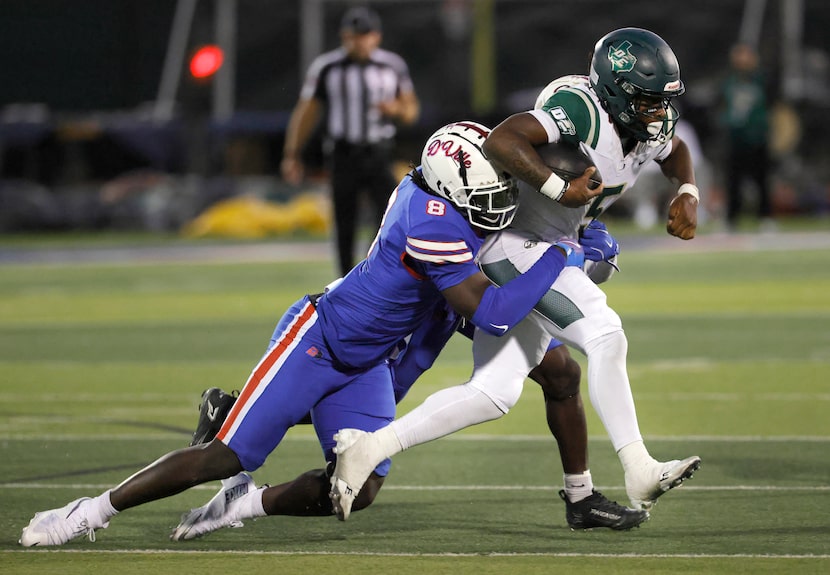DeSoto quarterback SaRod Baker (5) is chased and caught by Duncanville defensive lineman...