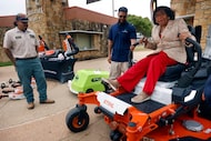 Dallas Council Member Carolyn King Arnold climbed onto a large electric mower to see how it...