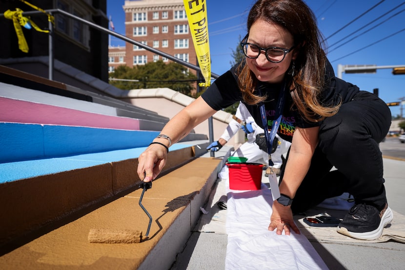 Senior pastor Rachel Griffin-Allison helps paint the stairs of Oak Lawn United Methodist...