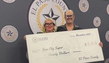 A couple wearing eccentric glasses hold a big check made out to Sun City Super from El Paso County.