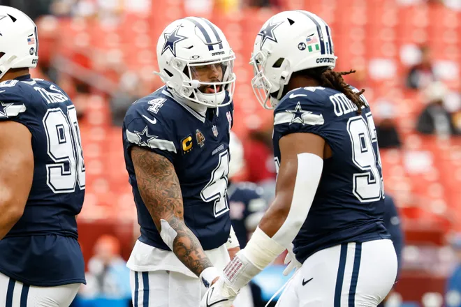 Dec 25, 2025; Landover, Maryland, USA; Dallas Cowboys quarterback Dak Prescott (4) greets defensive tackle Osa Odighizuwa (97) during warmups before the game against the Washington Commanders at Northwest Stadium. Mandatory Credit: Geoff Burke-Imagn Images