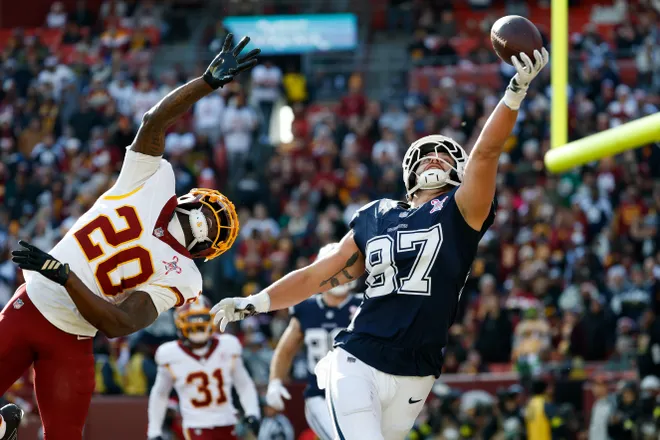 Dec 25, 2025; Landover, Maryland, USA; Dallas Cowboys tight end Jake Ferguson (87) makes a catch for a touchdown defended by Washington Commanders safety Quan Martin (20) in the first quarter at Northwest Stadium. Mandatory Credit: Amber Searls-Imagn Images