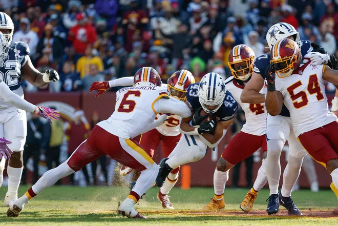 Dec 25, 2025; Landover, Maryland, USA; Washington Commanders cornerback Noah Igbinoghene (6) tackles Dallas Cowboys running back Malik Davis (43) in the first quarter at Northwest Stadium. Mandatory Credit: Amber Searls-Imagn Images