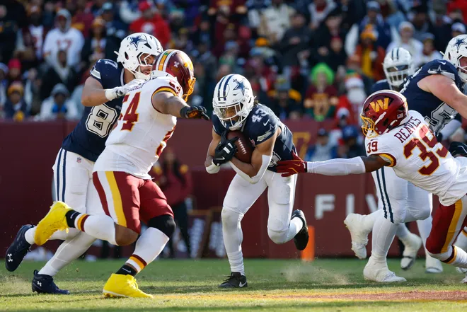Dec 25, 2025; Landover, Maryland, USA; Dallas Cowboys running back Malik Davis (43) carries the ball defended by Washington Commanders safety Jeremy Reaves (39) in the first half at Northwest Stadium. Mandatory Credit: Amber Searls-Imagn Images