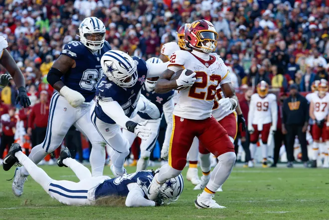 Dec 25, 2025; Landover, Maryland, USA; Washington Commanders running back Jacory Croskey-Merritt (22) avoids a tackle by Dallas Cowboys safety Malik Hooker (28) to score a touchdown in the second quarter at Northwest Stadium. Mandatory Credit: Amber Searls-Imagn Images